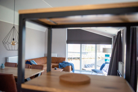 Modern living area at Waterlodge type 2 in Vakantiepark Bergumermeer, Netherlands, with large windows.