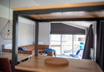 Salon moderne du Waterlodge type 2 au Vakantiepark Bergumermeer, Pays-Bas, avec de grandes fenêtres.
