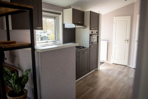 Modern kitchen space with gray cabinets and wood flooring at Waterlodge, Vakantiepark Bergumermeer, Netherlands.