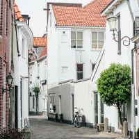 Encantadora calle adoquinada con casas blancas y una bicicleta en Nieuwland, Utrecht, Países Bajos.