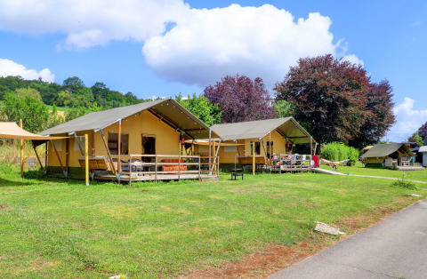 Tente safari au Camping Walsheim en Allemagne, installée sur pelouse verte avec arbres et ciel bleu.