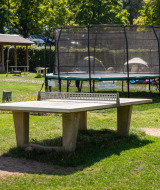 Mesa de tenis de mesa y trampolín al aire libre en Camping Walsheim, un parque vacacional en Saarland, Alemania.