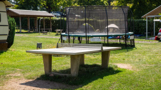 Mesa de tenis de mesa y trampolín al aire libre en Camping Walsheim, un parque vacacional en Saarland, Alemania.