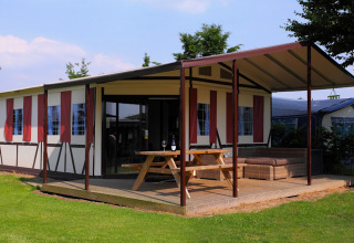 Tienda safari Tentlodge en Camping Vinkenhof, Países Bajos, con terraza cubierta y zona de descanso exterior.