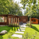 Et hyggeligt træhus ved Cozy Chalet på Bungalowpark Het Verscholen Dorp i Holland omgivet af grønne træer.