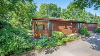 Veluwe lodge al Bungalowpark Het Verscholen Dorp nei Paesi Bassi, immerso nel verde degli alberi.