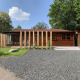 Moderne træhytte ved Tiny Chalet, Bungalowpark Het Verscholen Dorp, omgivet af grønt og blå himmel.