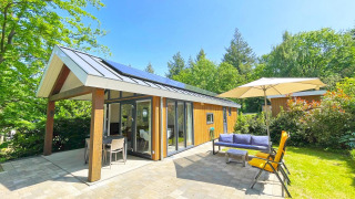 Cabaña ecológica moderna en De Thijmse Berg, Países Bajos, con patio, jardín y muebles de exterior.