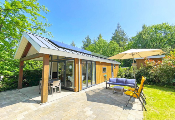 Cabaña ecológica moderna en De Thijmse Berg, Países Bajos, con patio, jardín y muebles de exterior.