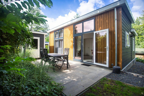 Nature Lodge en De Thijmse Berg, Países Bajos, con fachada de madera moderna y terraza exterior con vegetación.