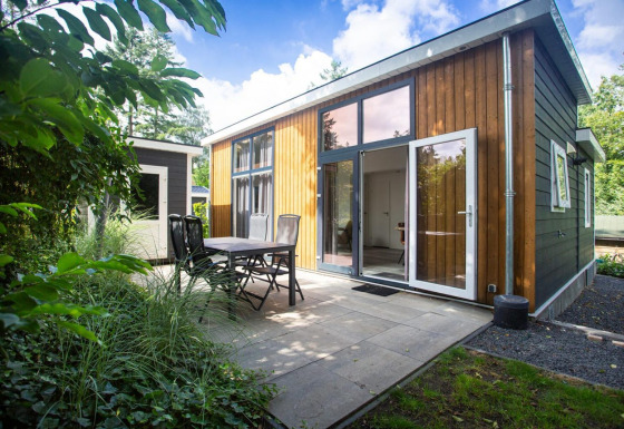 Nature Lodge en De Thijmse Berg, Países Bajos, con fachada de madera moderna y terraza exterior con vegetación.