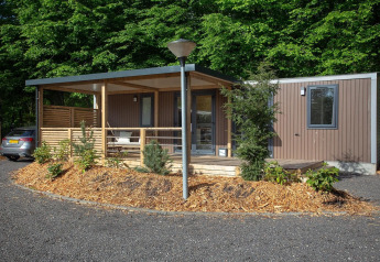 Familiehytte ved De Thijmse Berg i Holland, moderne design med veranda og omgivet af grøn natur.