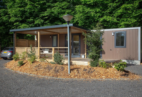 Foto de una familia cottage en De Thijmse Berg, Países Bajos, con porche y rodeada de vegetación y bosque.