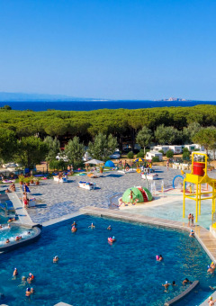 Vue sur la piscine et l’aire de jeux aquatiques du Camping Village Baia Blu La Tortuga, près de la mer.