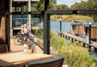 Due persone con biciclette ammirano la vista sul lago al Vakantiepark Leukermeer, Limburgo, Paesi Bassi.