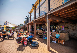 Außensitzbereich im Vakantiepark Leukermeer mit Gästen und Hunden an einem sonnigen Tag in Limburg.