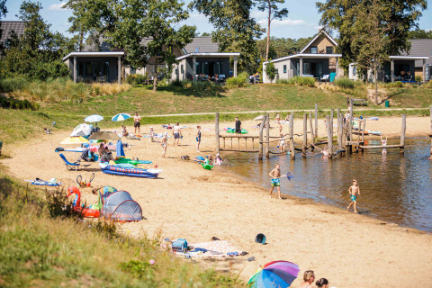 Vakantiepark Leukermeer en Limburg, Países Bajos, con familias, playa de arena y cabañas de vacaciones.