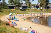 Vakantiepark Leukermeer in Limburg, Netherlands, with families, sandy beach, water, and holiday cabins.