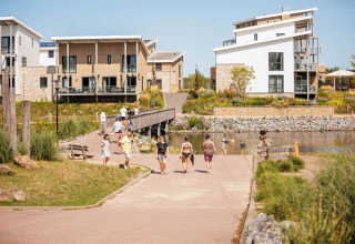 Vakantiepark Leukermeer holiday park in Limburg, Netherlands, with modern houses, water, and people walking.