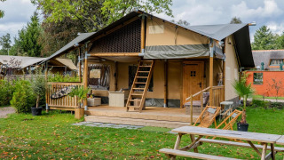 Tienda safari Ranger DeLuxe con jacuzzi en Camping Vossenberg, alojamiento de lujo en la naturaleza de los Países Bajos.