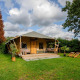 Safari-telt Cottage Kaa ved Camping Vossenberg i Holland med terrasse, havemøbler og grøn have.