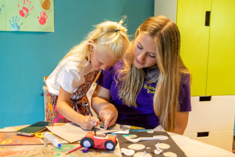Enfant et animatrice réalisant un atelier créatif au parc de vacances De Thijmse Berg à Utrecht, Pays-Bas.