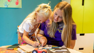 Niña y monitora hacen manualidades en el parque vacacional De Thijmse Berg en Utrecht, Países Bajos.