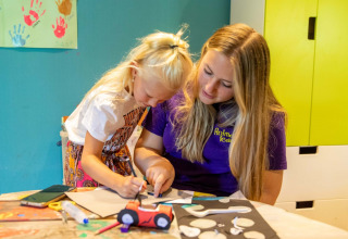 Enfant et animatrice réalisant un atelier créatif au parc de vacances De Thijmse Berg à Utrecht, Pays-Bas.