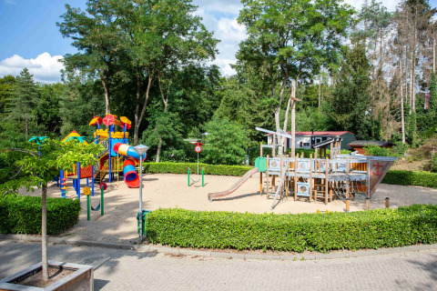 Parco giochi al De Thijmse Berg, Utrecht, Paesi Bassi, con scivoli colorati e nave pirata di legno sulla sabbia.