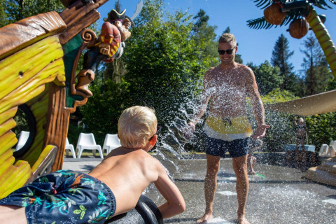 Niño rocía agua a un adulto en una zona de juegos acuáticos en De Thijmse Berg, Utrecht, Países Bajos.