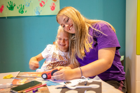 Zwei Kinder basteln fröhlich zusammen am Tisch im Ferienpark De Thijmse Berg in Utrecht, Niederlande.