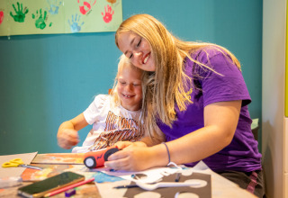 Two kids enjoy doing arts and crafts together at a table in De Thijmse Berg holiday park, Utrecht, Netherlands.