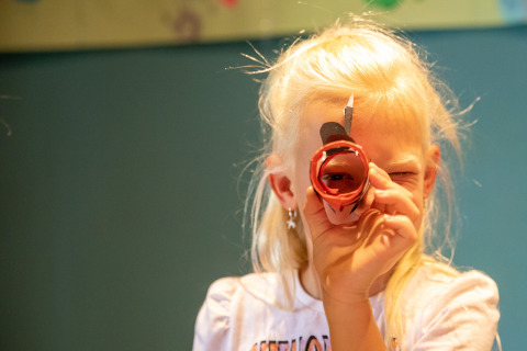 A child peers through a handmade cardboard tube at De Thijmse Berg holiday park in Utrecht, Netherlands.
