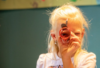 A child peers through a handmade cardboard tube at De Thijmse Berg holiday park in Utrecht, Netherlands.