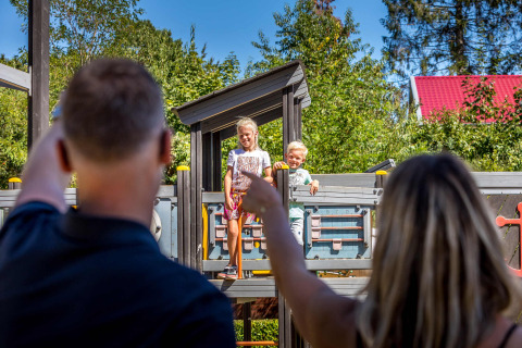 Padres saludan a sus hijos en el parque infantil del parque vacacional De Thijmse Berg en Utrecht, Países Bajos.