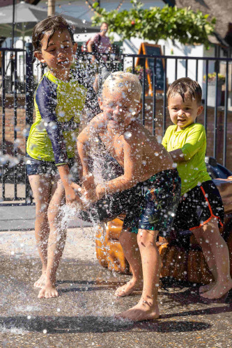 Kinderen spetteren met water in vakantiepark De Thijmse Berg in Utrecht op een zonnige dag.