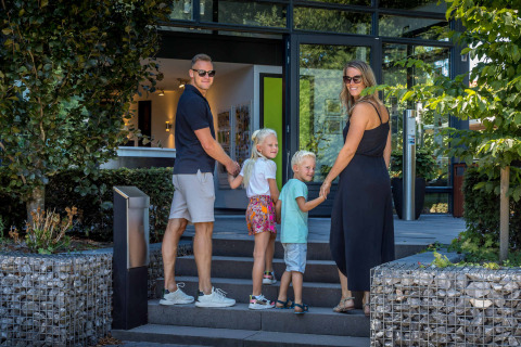 Une famille de quatre personnes se tient la main devant De Thijmse Berg, un parc de vacances à Utrecht, Pays-Bas.