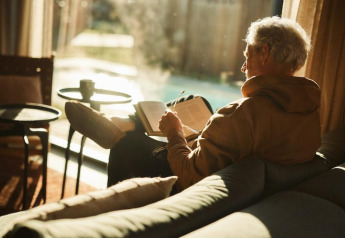 An elderly man relaxes reading a book at Unbrick One | Sauna and Pool, Brinckerduyn lodge, Netherlands.