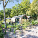 Billede af Lodge Royal Eco tiny house på Résidence Lage Vuursche i Holland omgivet af grønne træer.