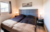 Slaapkamer met twee eenpersoonsbedden, modern hoofdbord en lampen bij Berkenhoeve, Résidence Lichtenvoorde.