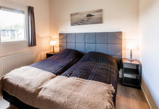 Dormitorio con dos camas individuales, cabecero moderno y lámparas en Berkenhoeve, Résidence Lichtenvoorde.