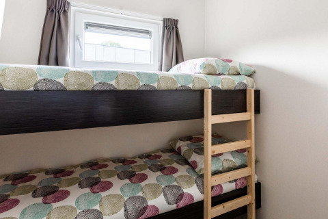 Stapelbed met kleurrijk bedlinnen en een venster bij Berkenhoeve, Résidence Lichtenvoorde, Nederland.