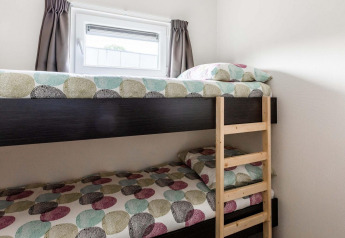 Stapelbed met kleurrijk beddengoed en raam bij Berkenhoeve, Résidence Lichtenvoorde, Nederland.