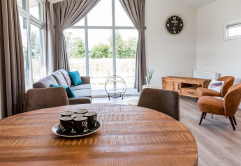 Woonkamer van Berkenhoeve lodge op Résidence Lichtenvoorde, Nederland, met grote ramen en moderne inrichting.