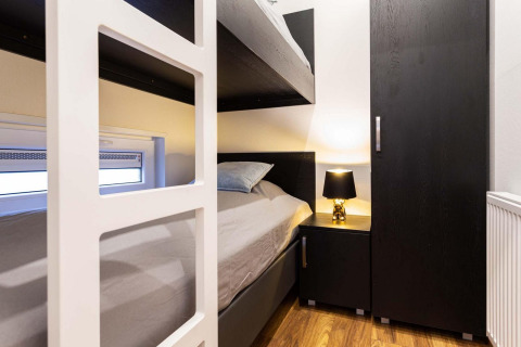 Moderne stapelbedkamer bij Berkenhoeve Wellness, Résidence Lichtenvoorde, Nederland met donkere meubels.