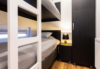 Moderne stapelbedkamer in Berkenhoeve Wellness, Résidence Lichtenvoorde, Nederland met donker meubilair.