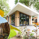 Moderne lodge ved Resort Veluwe i Holland med wellness-område og spabad, omgivet af frodige grønne omgivelser.