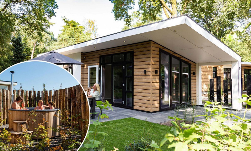 Moderne Silva Wellness lodge met houten gevel, ruim terras en buiten hottub in de tuin met ontspannende gasten.