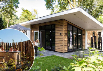 Moderne lodge ved navn Silva Wellness med træfacade og hottub i haven, omgivet af grønt og folk der slapper af.