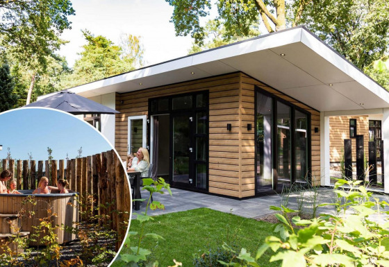 Lodge moderno Silva Wellness con rivestimento in legno e vasca idromassaggio esterna in giardino con persone rilassate.